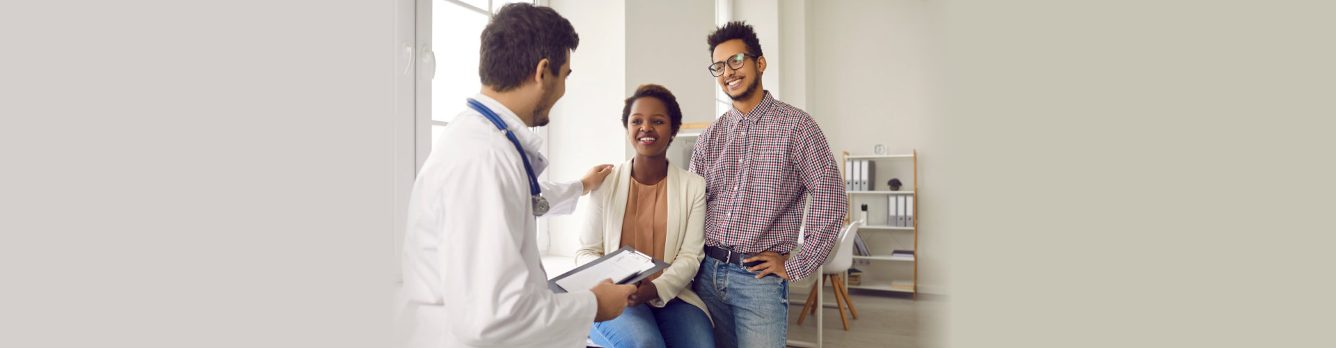 Male doctor comfort support multiracial couple patients at consultation in clinic